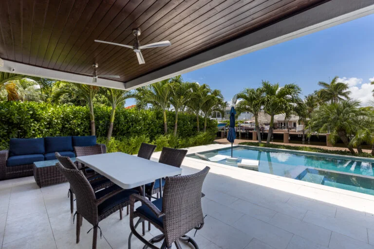 backyard-modern-house-with-swimming-pool-artificial-grass-stone-path-trees-chairs