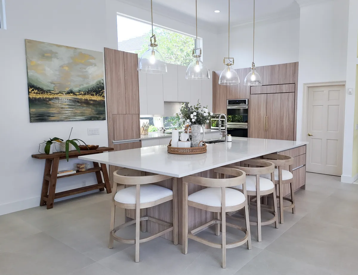 Kitchen with a waterfall quartz island and wood-grain cabinetry in Palm Beach Gardens, Florida.