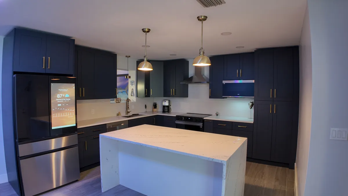 Navy shaker kitchen with brass fixtures and quartz counters in West Palm Beach, FL