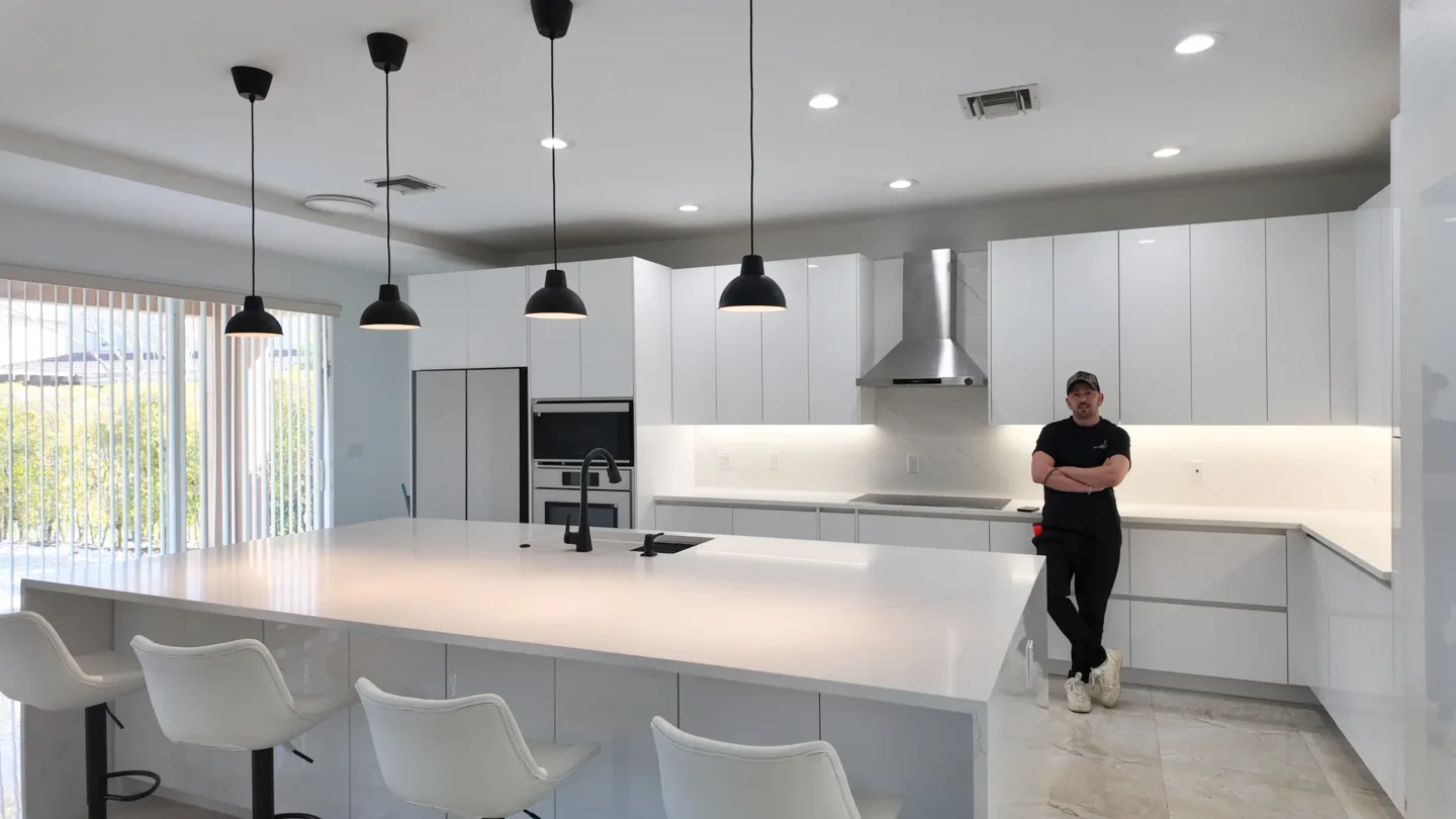Open-plan kitchen remodel with an island and pendant lighting in Miami, FL
