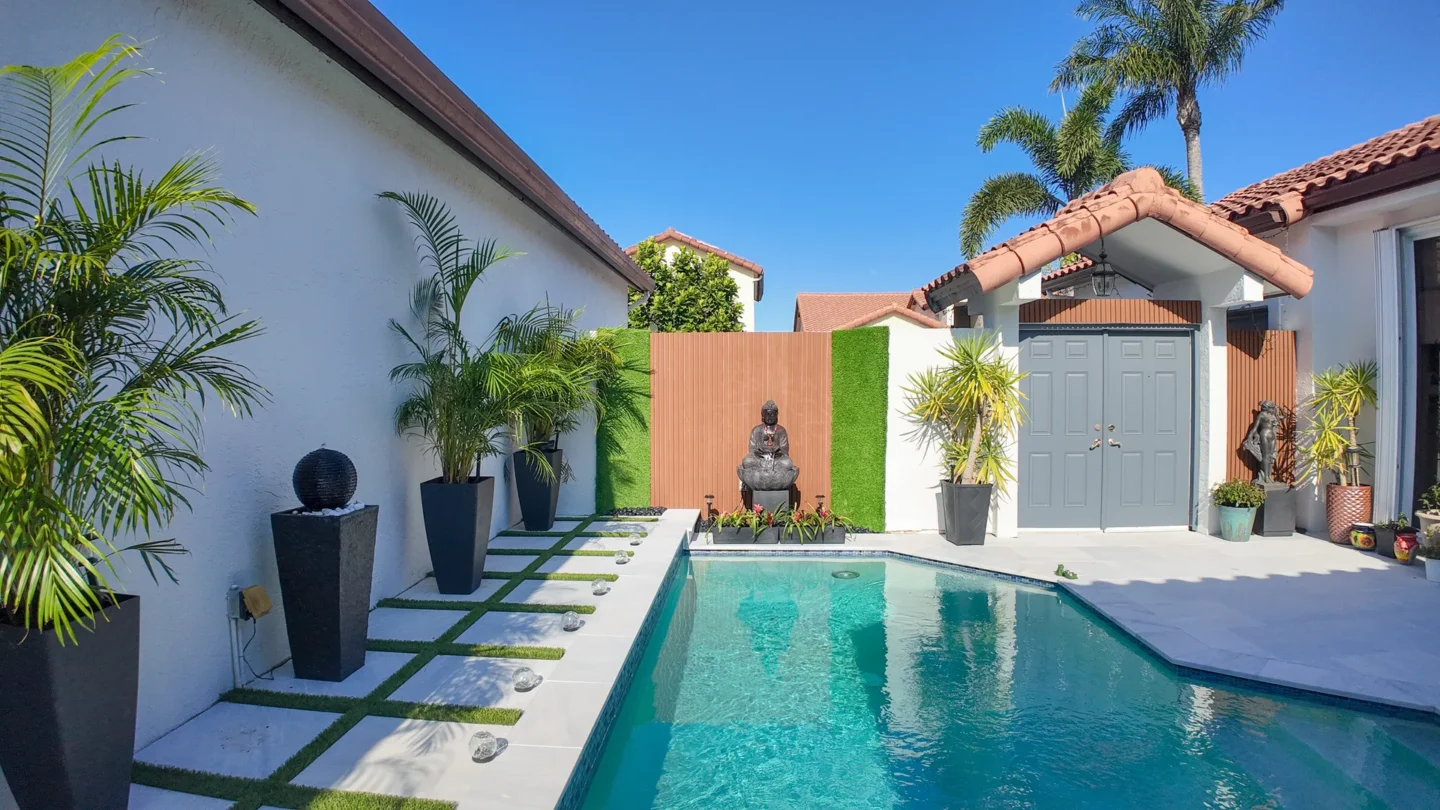 Marble paver pool deck with a modern pool and privacy wall in Miami