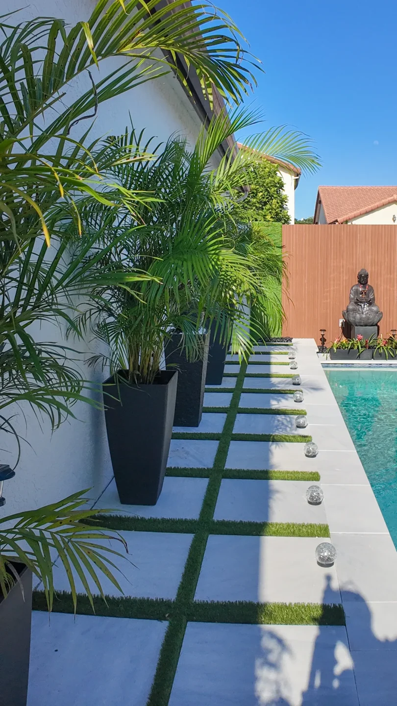Pool deck built with large-format pavers and turf grass joints in a Miami backyard