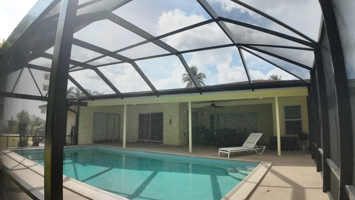 Interior view of a screened pool enclosure with mansard roof in Miami
