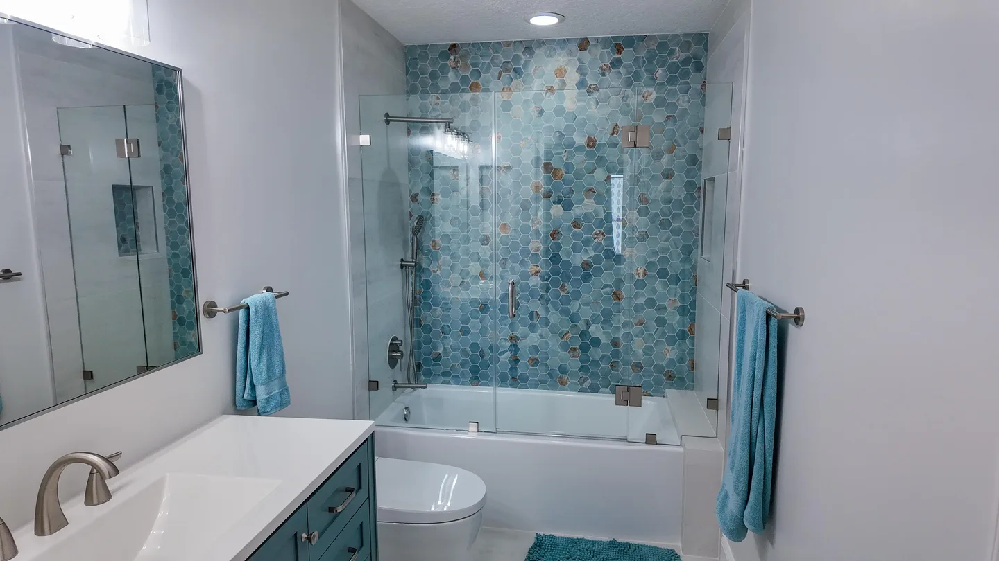 Blue-tile bathtub and shower combination in a remodeled bathroom