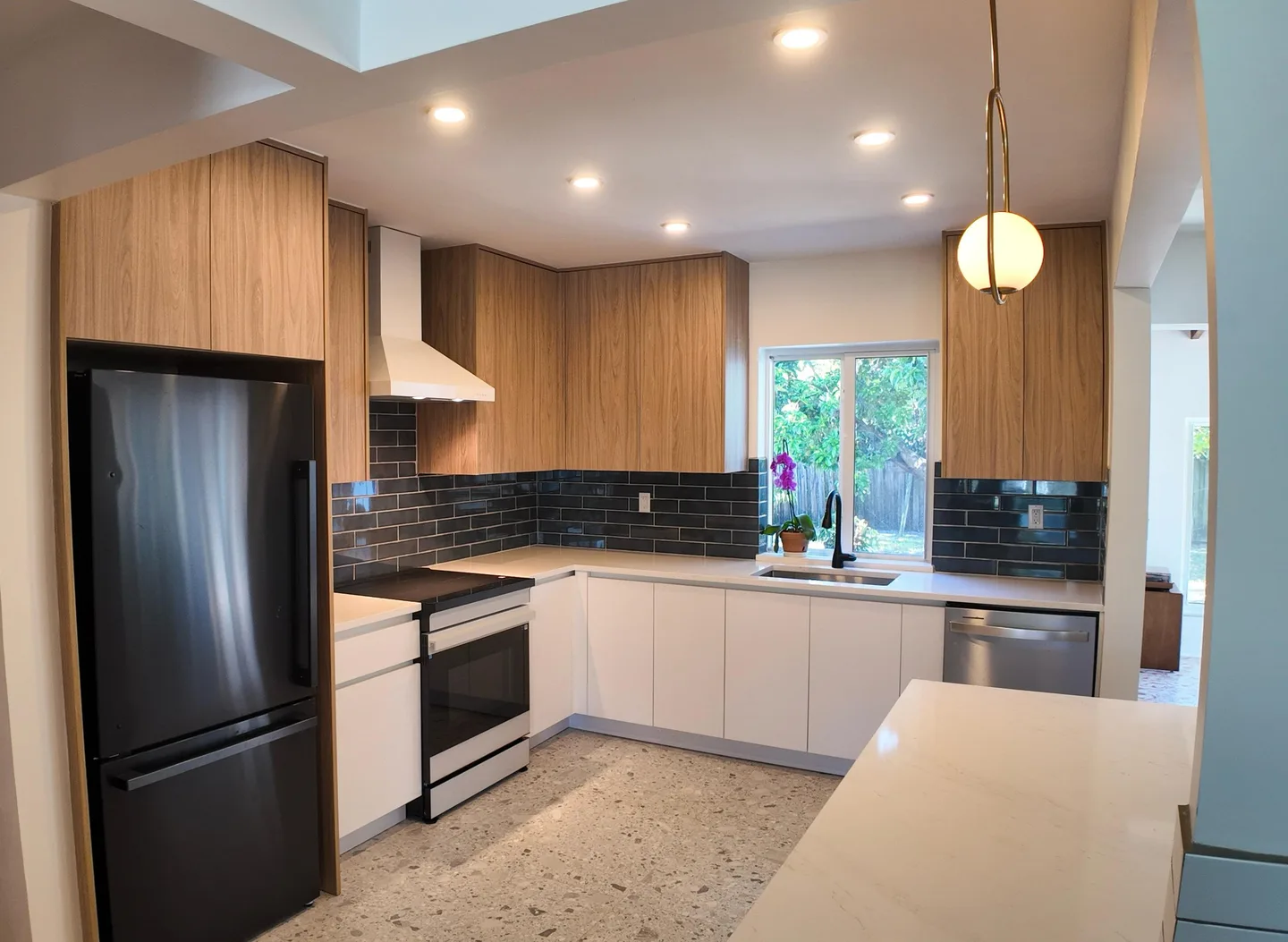 Custom kitchen with wood and white cabinets and a quartz island in North Miami