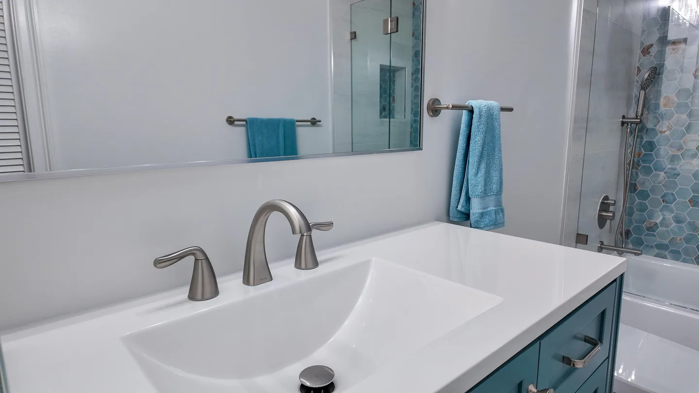 Glass-enclosed walk-in shower beside a white vanity in a Palm Beach Gardens bathroom