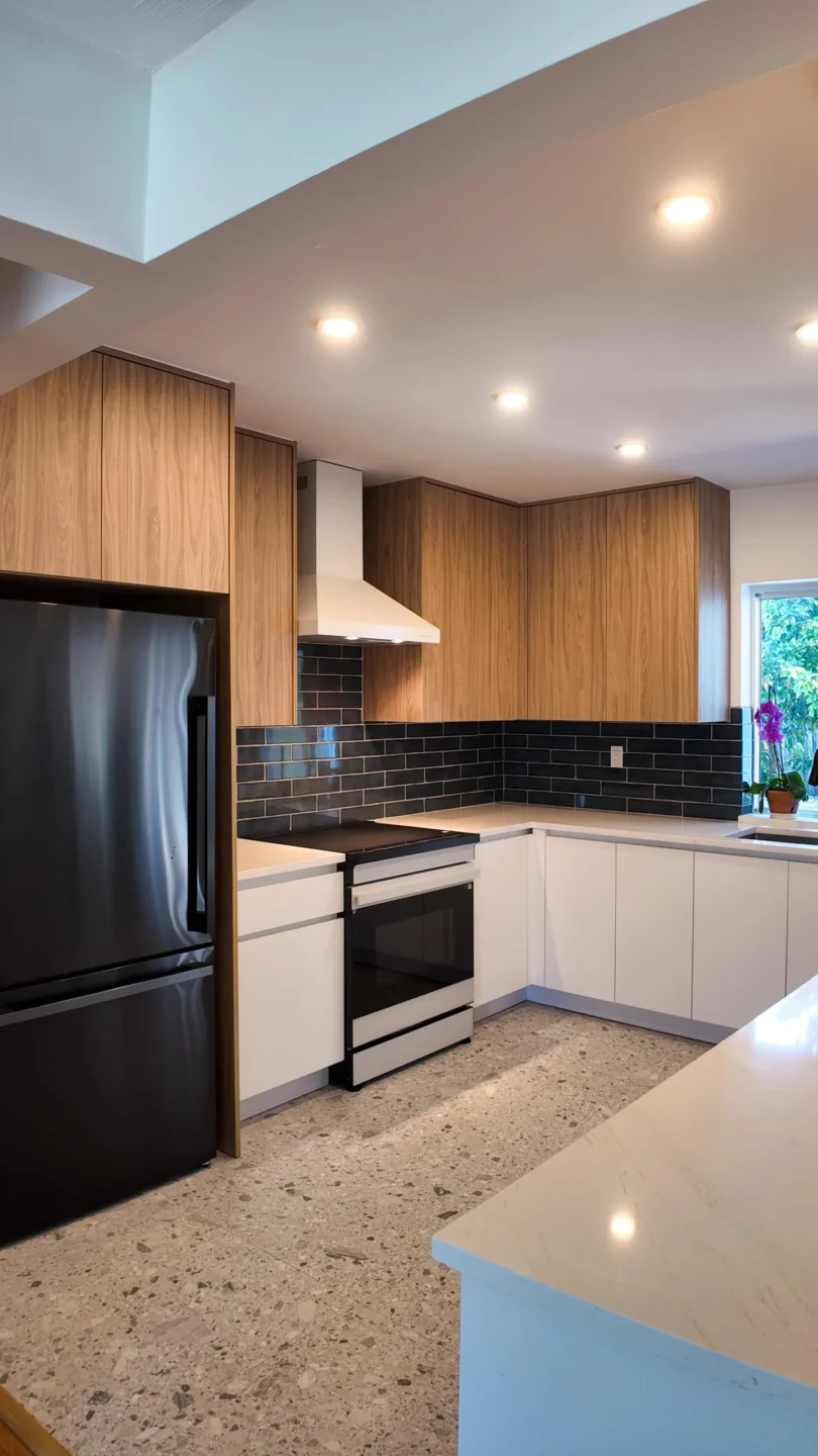 Kitchen island and cabinetry with black appliances in a Miami kitchen remodel