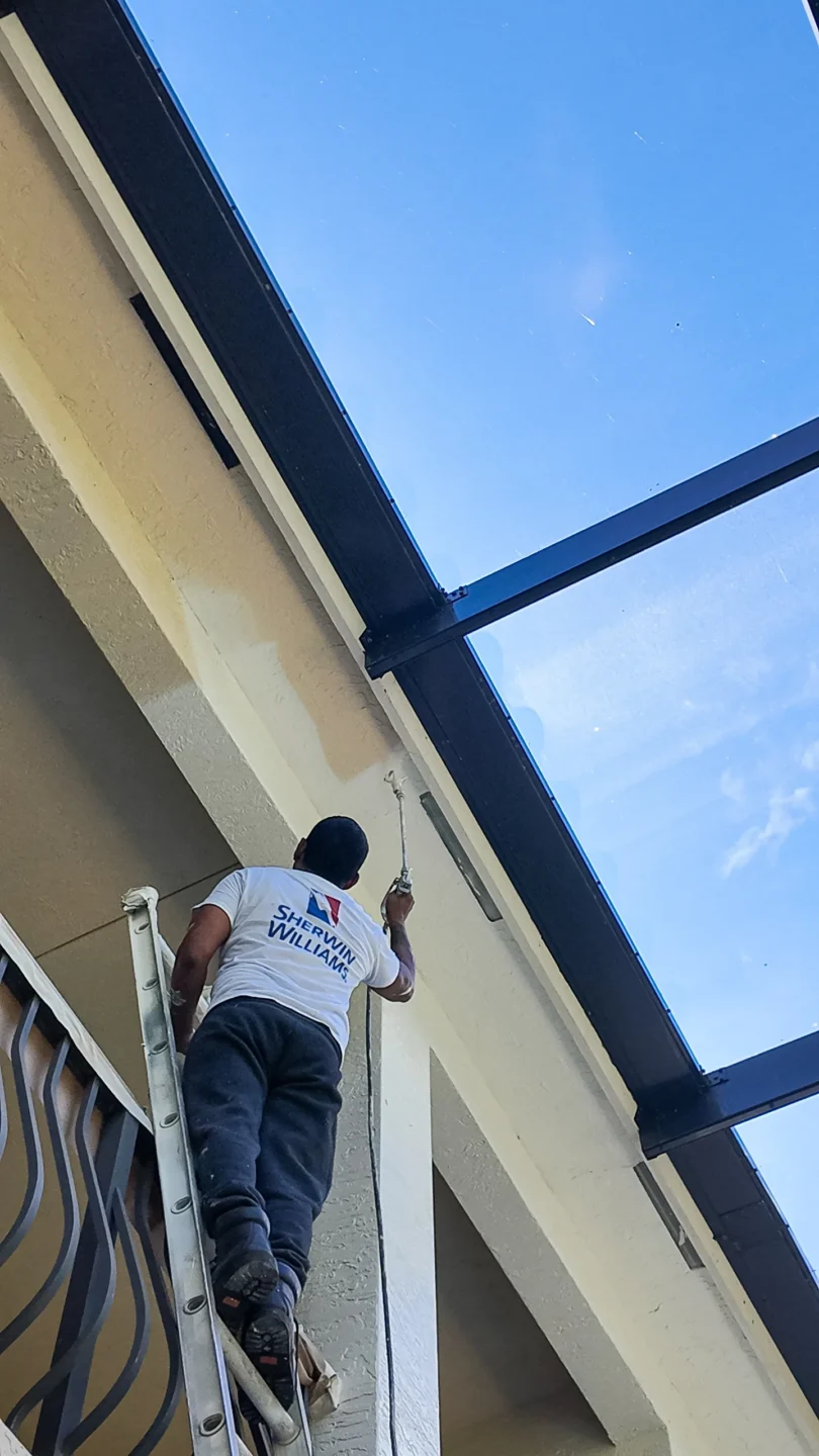 Contractor on a ladder working on a South Florida home exterior