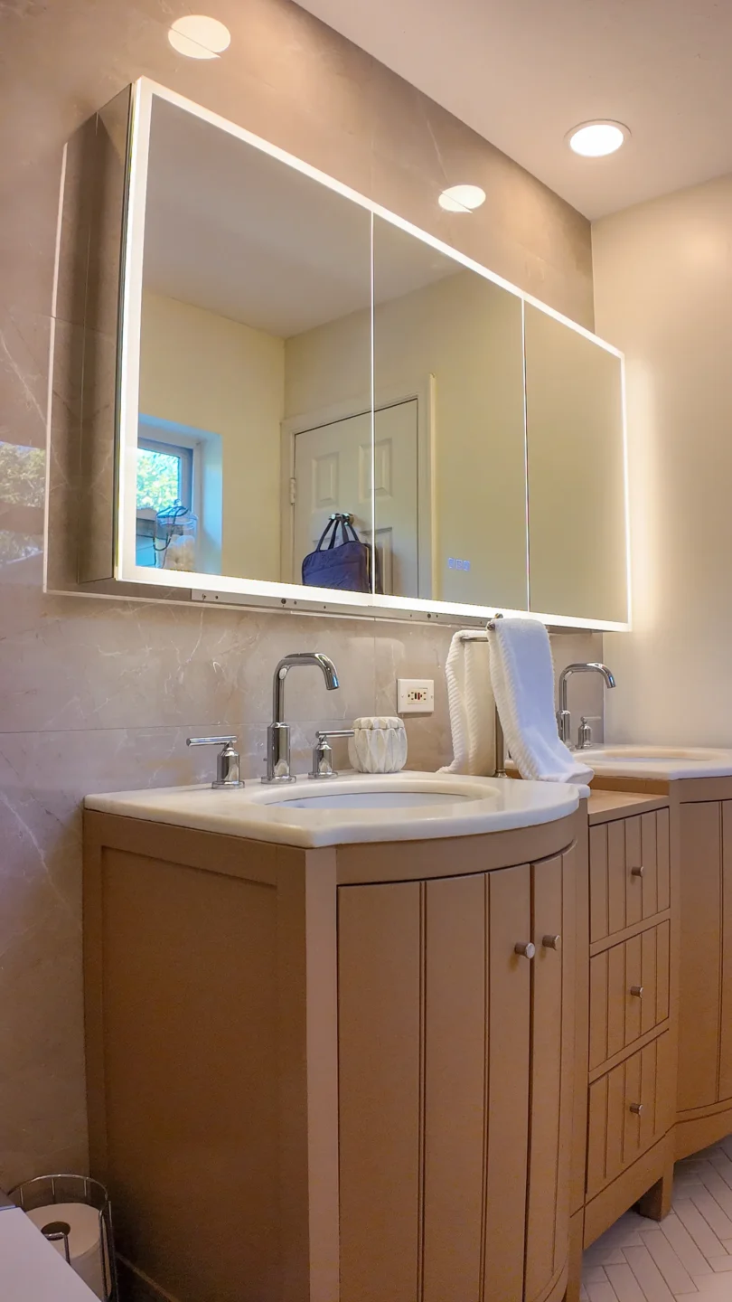 Single-sink wood vanity with a wide mirror in a remodeled bathroom