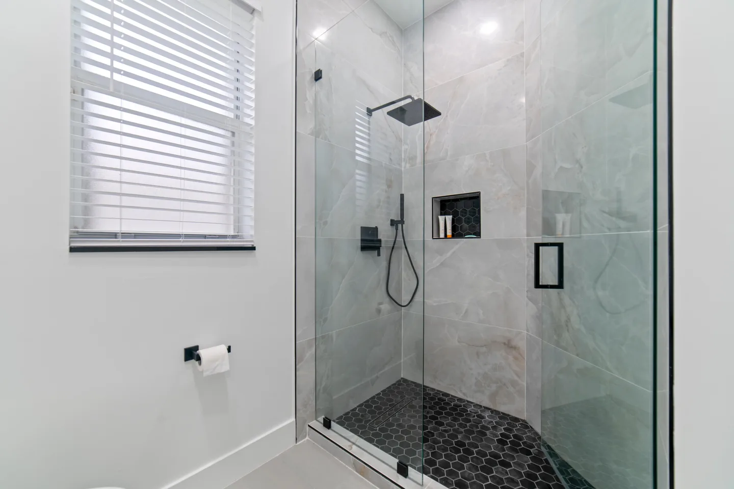 Walk-in shower with a glass door and a raised curb that keeps water inside the enclosure