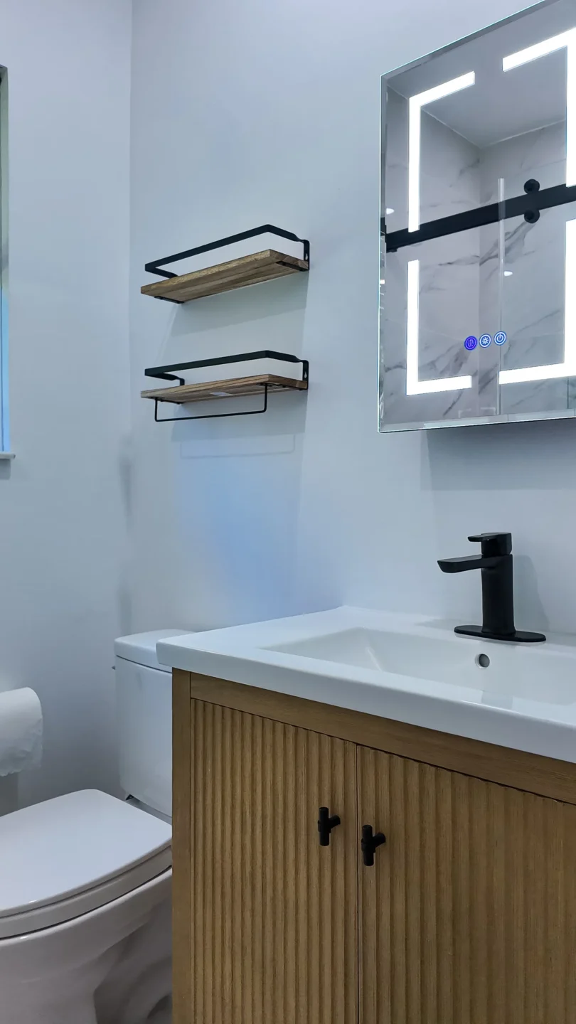 Single wood vanity with a stone countertop in a Miami Springs bathroom